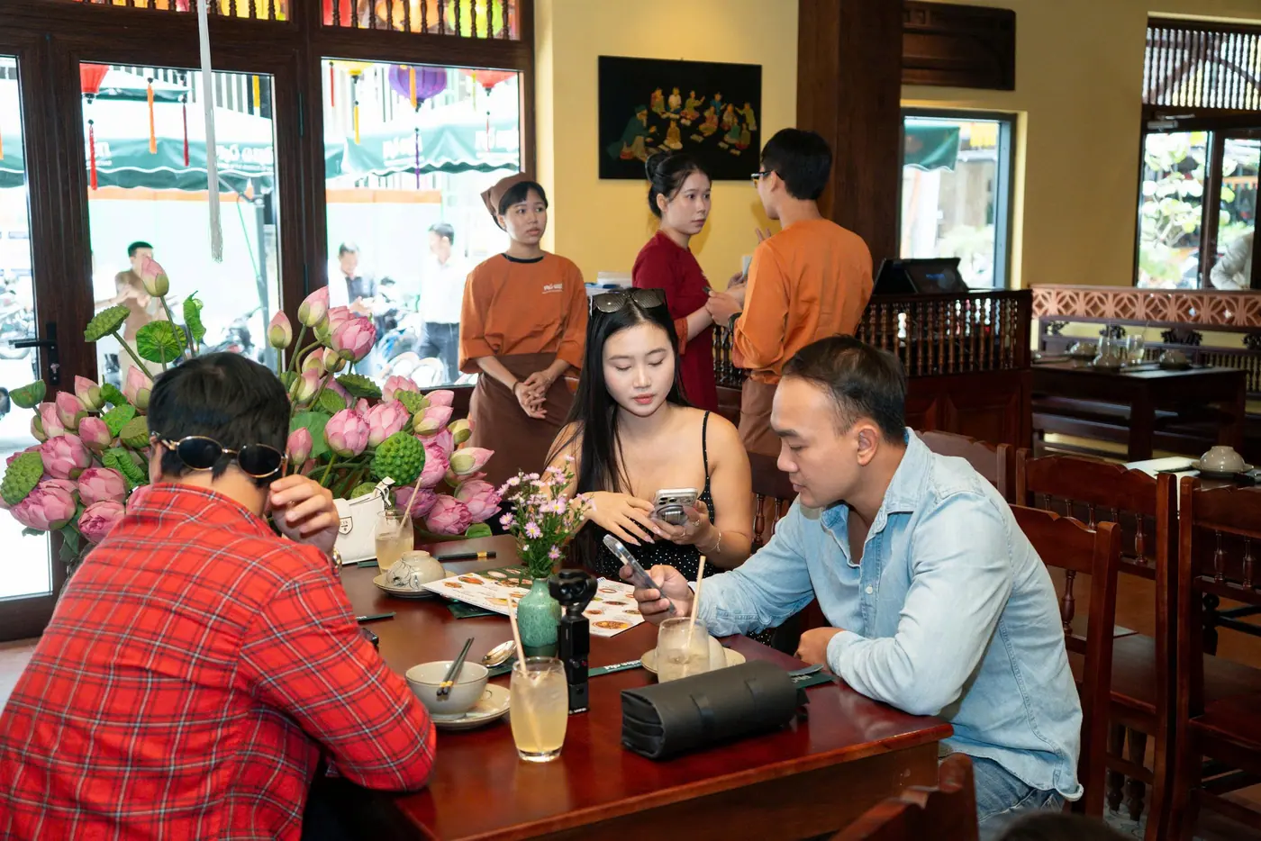 Nhóm bạn ngồi trò chuyện bên bàn ăn trong quán