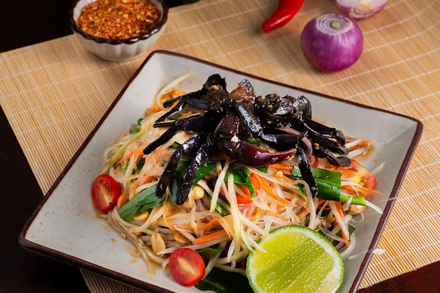 Đu đủ xanh bào sợi giã cối cùng đậu phộng, cà chua bi và chanh — nền chung của mọi đĩa som tum, dù phần ăn kèm mỗi nơi mỗi khác